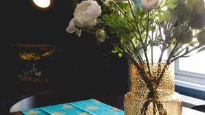 A vase with white flowers and green leaves on a table. - Designer Retreat 5 Location Balcony Parking (Hove)