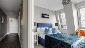 A bedroom with a bed, a desk, and a window. - The Lanes Gem Penthouse Rooftop Terrace Sea View (Brighton)
