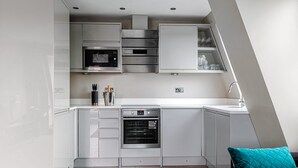 A modern kitchen with built-in appliances, a dishwasher, and a countertop with a sink. - The Lanes Gem Penthouse Rooftop Terrace Sea View (Brighton)