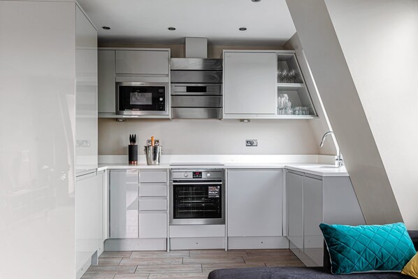 A modern kitchen with built-in appliances, a dishwasher, and a countertop with a sink.