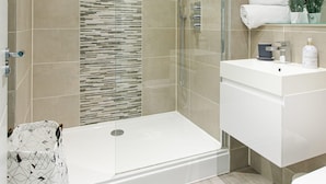 A modern bathroom with a glass shower enclosure, a white vanity, and a mirror above the sink. - Gorgeous 5 Star Location 2 min to Brighton Beach (Brighton)