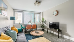 A modern living room with a sofa, coffee table, TV, and dining area. - The Lanes Stellar Stay Sea View 2min Walk to Beach (Brighton)