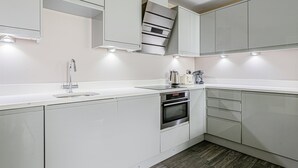 A modern kitchen with white cabinetry, stainless steel appliances, and under-cabinet lighting. - The Lanes Stellar Stay Sea View 2min Walk to Beach (Brighton)