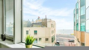 A view from a window overlooking a building with a street and a body of water. - The Lanes Stellar Stay Sea View 2min Walk to Beach (Brighton)