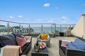 A rooftop terrace with a sofa, armchairs, and a table with a bottle and glasses. - Brighton Beach City Penthouse Sea Views Balcony (Brighton)