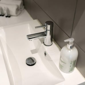 A bathroom sink with a chrome faucet and a soap dispenser.