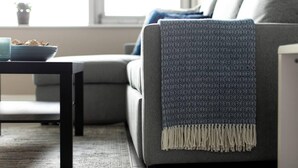 A modern living room with a grey sofa, a patterned throw blanket, and a small table with a bowl of snacks. - Spacious Perfect Location Moments Away From Pier (Brighton)