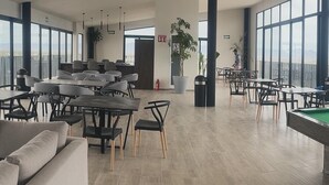 A spacious indoor area with multiple seating arrangements, including tables and chairs, and a pool table. - Beautiful Appartment in front of the TSM Stadium (Torreon)