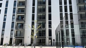 A modern building with a pool, lounge chairs, and a tennis court. - Beautiful Appartment in front of the TSM Stadium (Torreon)