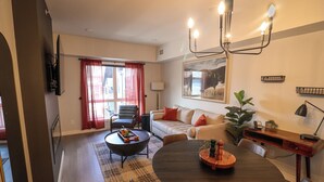 Una sala de estar moderna con comedor, que incluye un juego de sofá, una mesa de centro y una mesa de comedor con sillas.