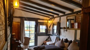 A cozy room with a bed, a chair, a desk, and a window with curtains. - Hotel b&b altes hinterhäusel  (Freiberg)