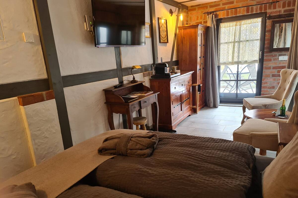 A hotel room with a bed, a desk, a television, and a view of the outdoors.