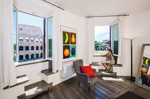 Una habitación moderna con un ventanal grande, una silla, un radiador y una obra de arte en la pared.