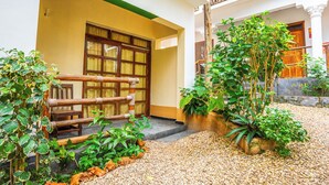 A courtyard with a wooden fence, potted plants, and a gravel path. - La Fotana Restaurant And Bungalows (Kendwa)