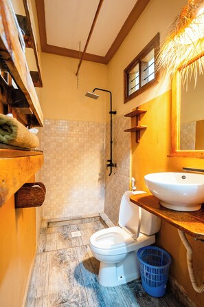 Un baño pequeño con inodoro, lavabo y ducha.