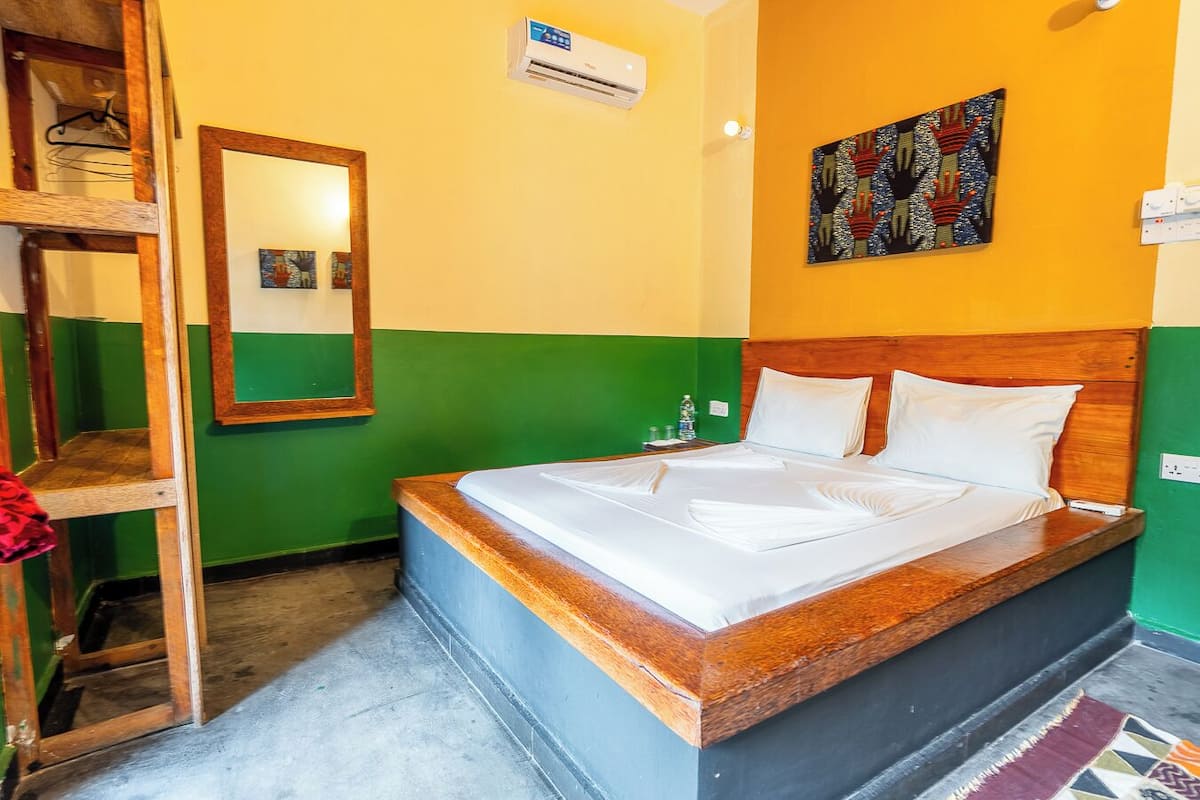 Una habitación con una cama, un espejo y un cuadro en la pared.