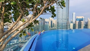A rooftop infinity pool with a city skyline in the background.