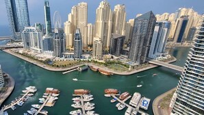A marina with numerous boats docked, surrounded by high-rise buildings with modern architecture.