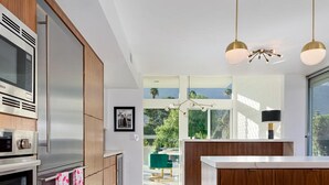 Une cuisine moderne dotée d’appareils électroménagers en acier inoxydable, de meubles en bois et d’un grand îlot central.