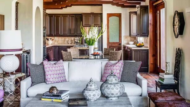 A cozy living room with a white sofa, decorative pillows, and a coffee table with books and vases. - Villa Vista - Spanish Luxury Pool Wifi (Palm Springs)