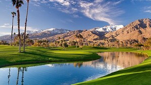 A golf course with a pond, palm trees, and mountains in the background. - Villa Vista - Spanish Luxury Pool Wifi (Palm Springs)