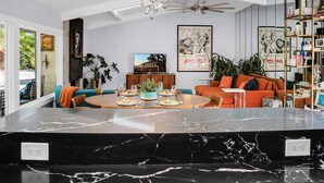 A modern living room with a marble island, a ceiling fan, and a bookshelf. - Escapade in Palm Springs (Palm Springs)
