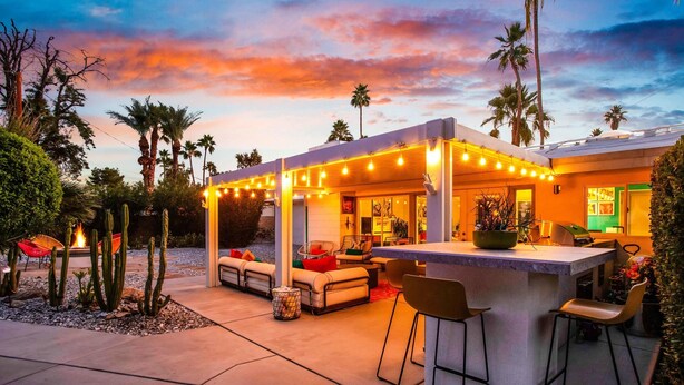 An outdoor patio area with a bar, seating, and a pool. - Escapade in Palm Springs (Palm Springs)
