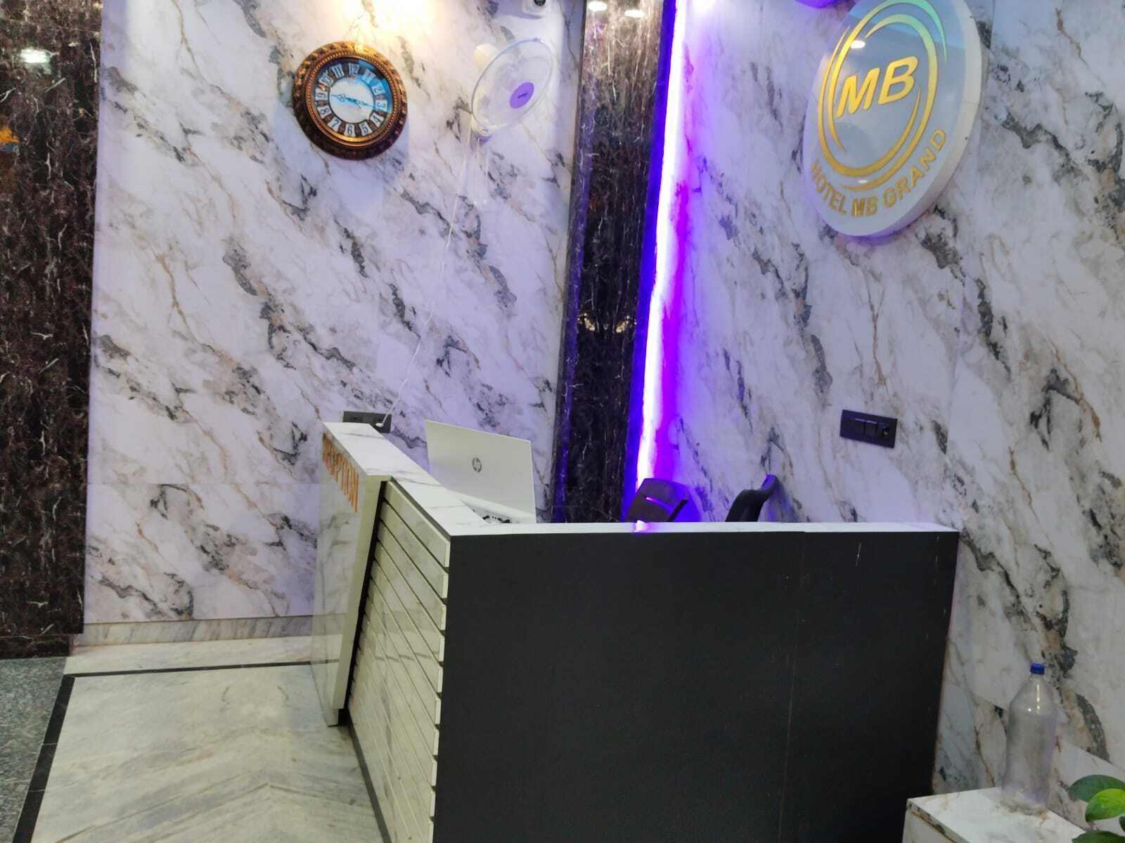 A marble reception desk with a clock and a neon sign.