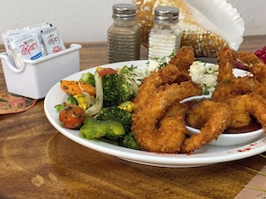 A plate of fried shrimp, vegetables, and a side of coleslaw. - The Palms At Coco Beach (Carrillos)