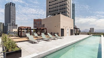 Una piscina al aire libre, sombrillas, tumbonas