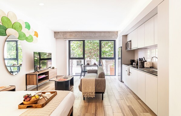 A modern kitchen with a dining area, large windows, and a view of the outdoors. - Kukun Reforma Downtown (Mexico City)
