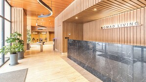 A reception area with a wooden panel wall, a marble counter, and potted plants. - Kukun Reforma Downtown (Mexico City)