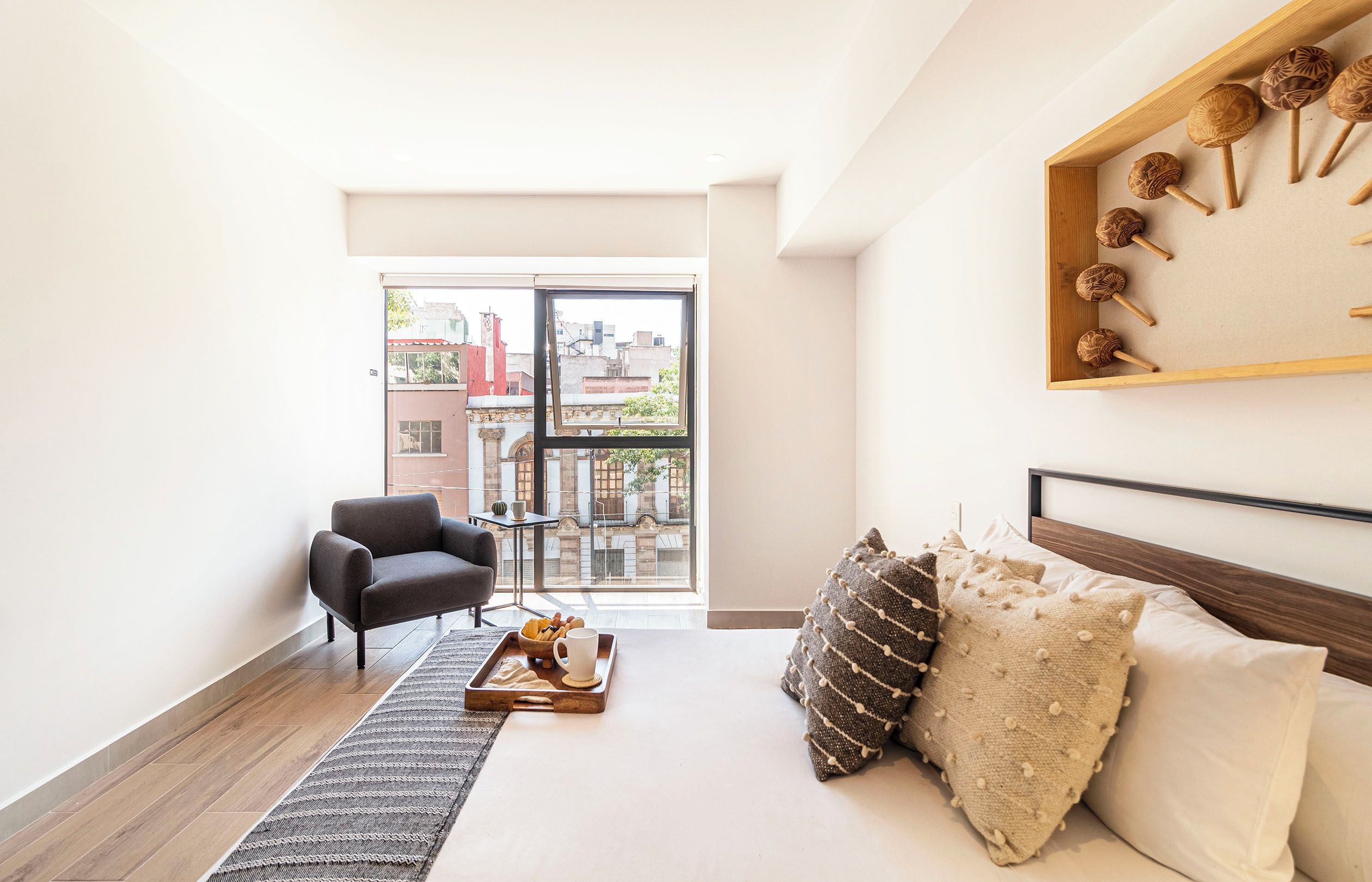 Una sala de estar moderna con un sofá, una mesa de centro y vistas de la ciudad a través de un ventanal.
