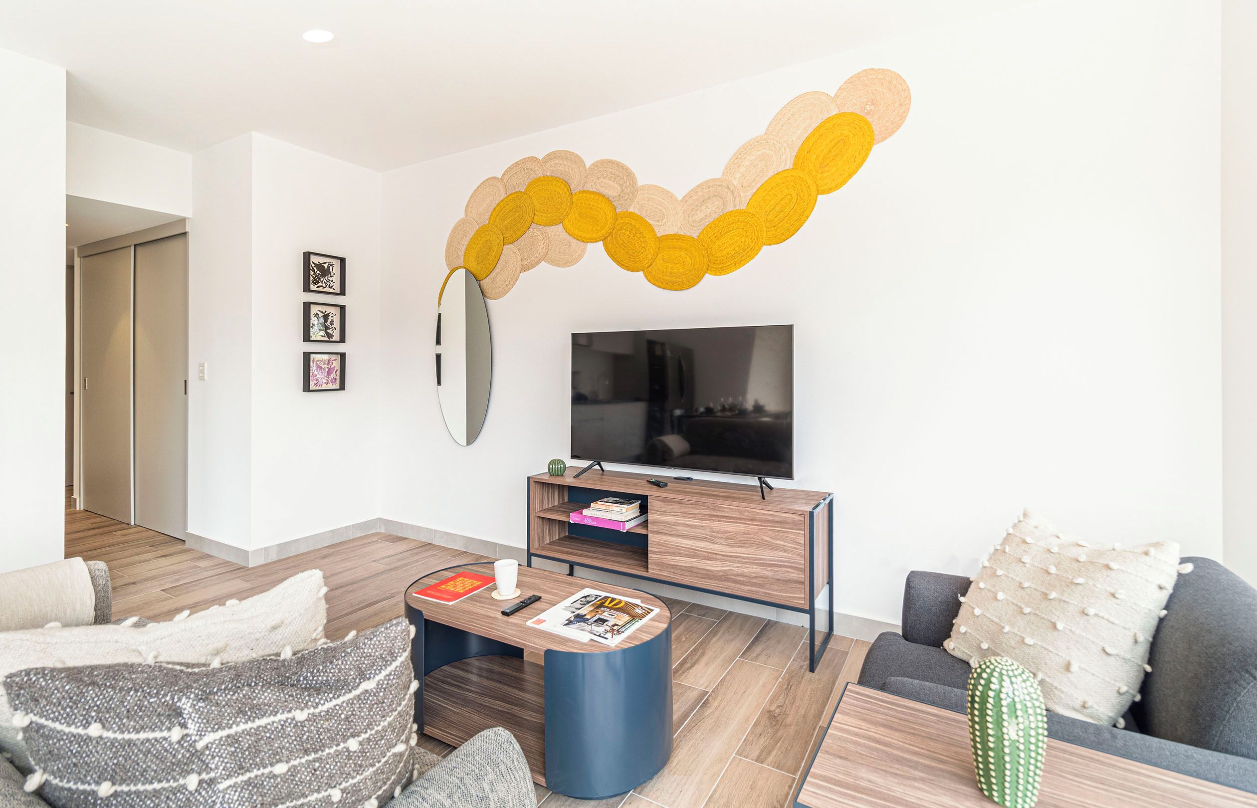 Un salon moderne avec un téléviseur à écran plat, une table basse et un canapé.