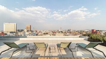 Una piscina al aire libre, sombrillas, tumbonas