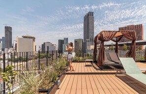 A rooftop terrace with a view of a city skyline, a pergola, and lounge chairs. - Kukun Reforma Downtown (Mexico City)