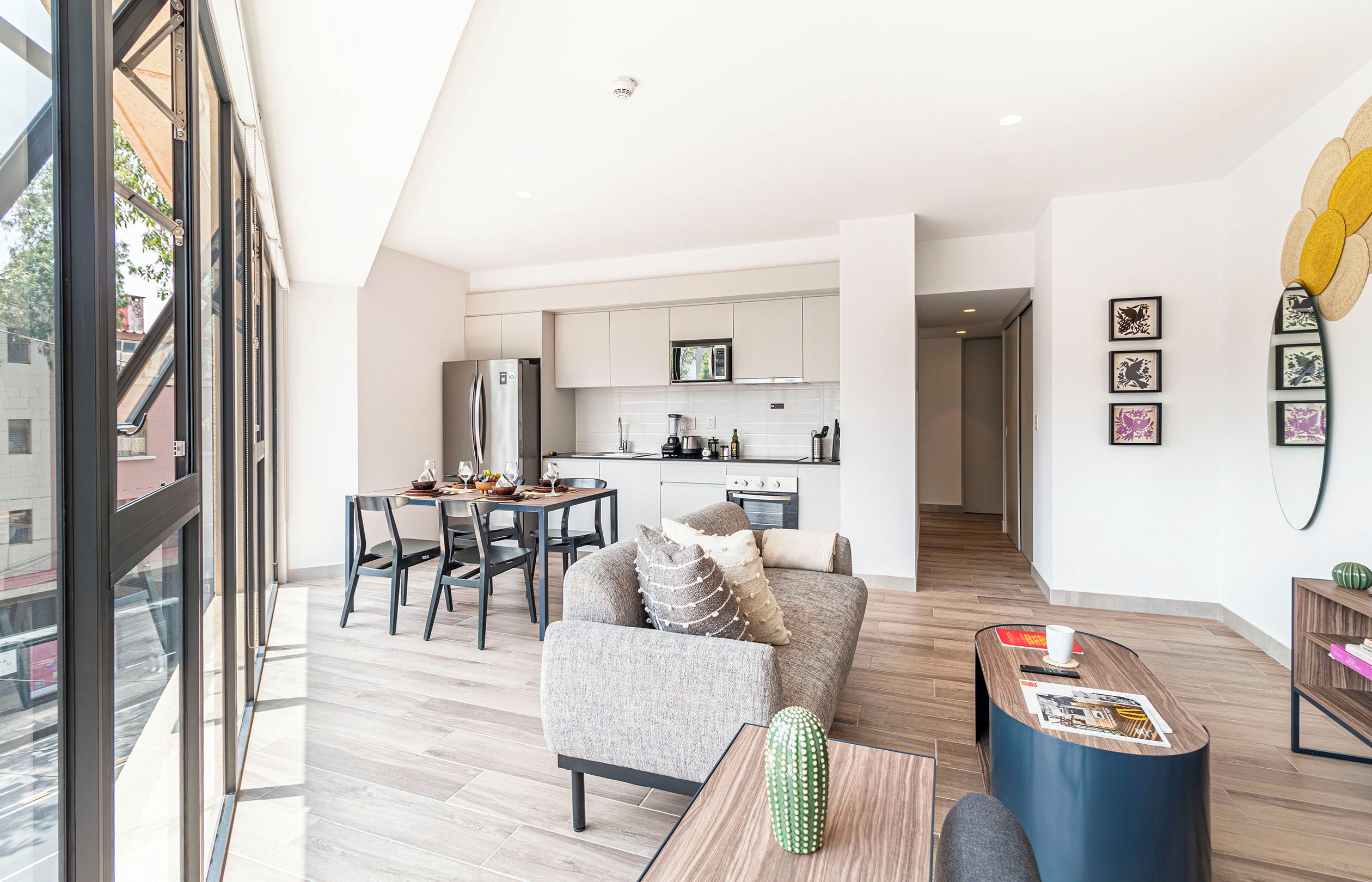 A modern apartment with a dining area, kitchen, and living space.
