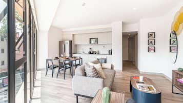 A modern apartment with a dining area, kitchen, and living space.