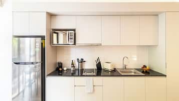 Una cocina moderna con un refrigerador de acero inoxidable, un microondas y una tostadora sobre la encimera.