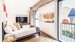 A modern bedroom with a bed, a flat-screen TV, a wall-mounted shelf with decorative items, and a large window. - Kukun Reforma Downtown (Mexico City)