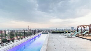 A rooftop pool with a cityscape view, lounge chairs, and a pergola. - Kukun Reforma Downtown (Mexico City)