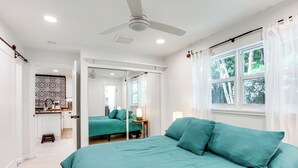 A bedroom with a bed, a ceiling fan, and a window with curtains. - Vibrant North Palm Beach Home ~ 2 Mi to Beach! (North Palm Beach)