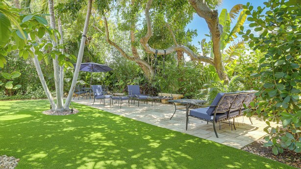 A patio area with outdoor furniture and a lawn. - Vibrant North Palm Beach Home ~ 2 Mi to Beach! (North Palm Beach)