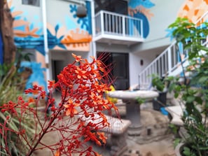 Un edificio con un mural colorido, un balcón blanco y una escalera.