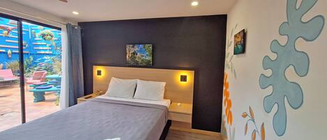 Een moderne hotelkamer met een groot bed, een nachtkastje en een wandlamp.