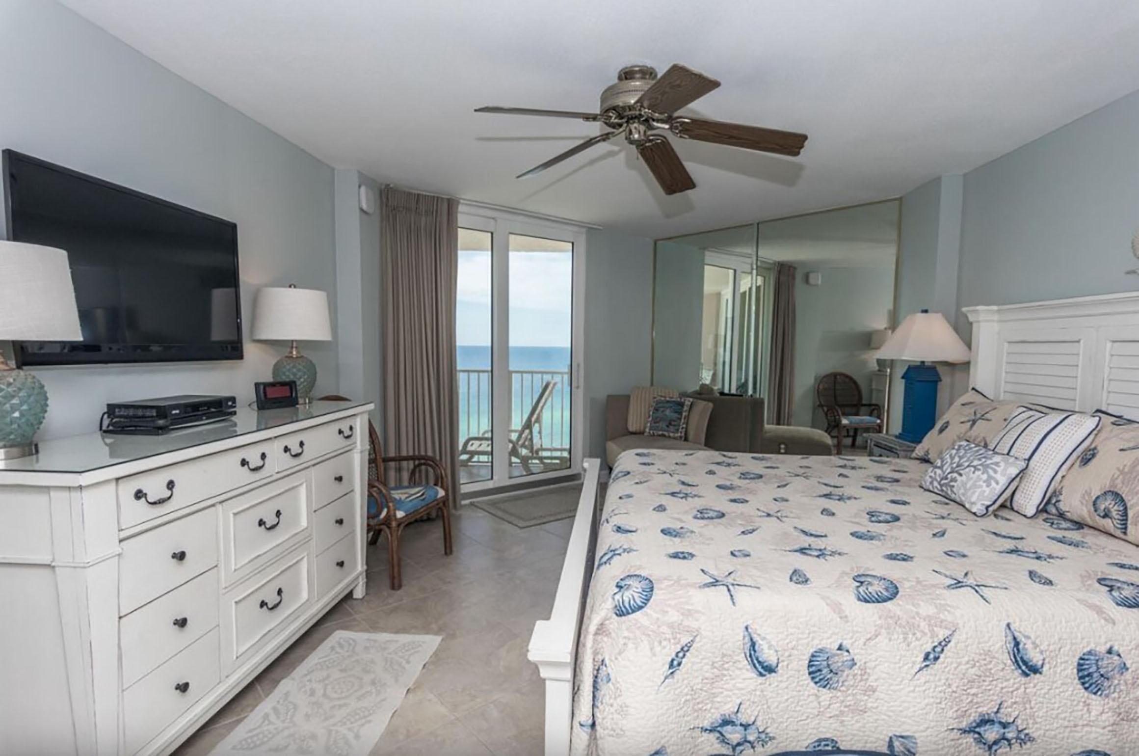A bedroom with a bed, a TV, a dresser, and a chair.