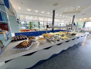 A buffet with various food items and a blue and white color scheme. - Hotel Palace (Nessebar)