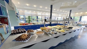 A buffet with various food items and a blue and white color scheme. - Hotel Palace (Nessebar)