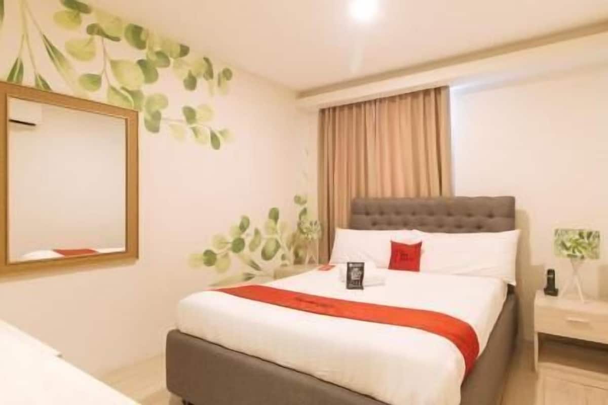 Une chambre d’hôtel avec un lit, une table de chevet, un miroir et une fenêtre avec des rideaux.
