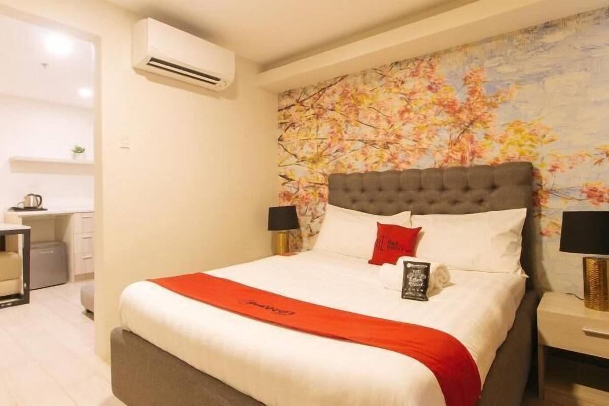 Une chambre d’hôtel équipée d’un lit, d’un bureau et d’un appareil de climatisation.